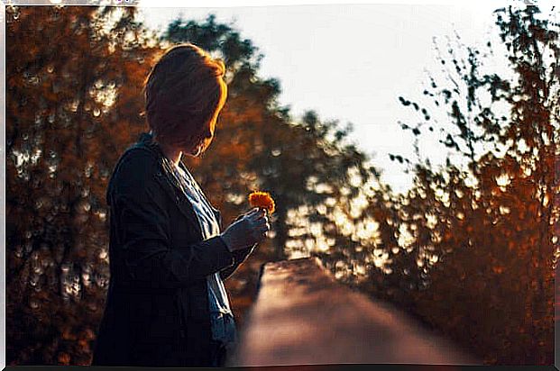 A woman looking at a flower