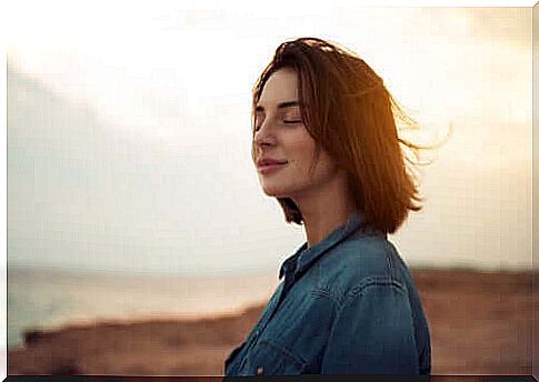 A woman enjoys the sun with her eyes closed