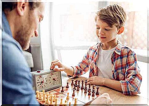 A father and his son playing chess.