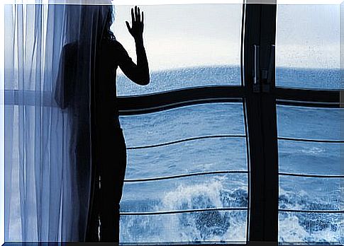 Woman-looking-at-the-sea-through-the-window